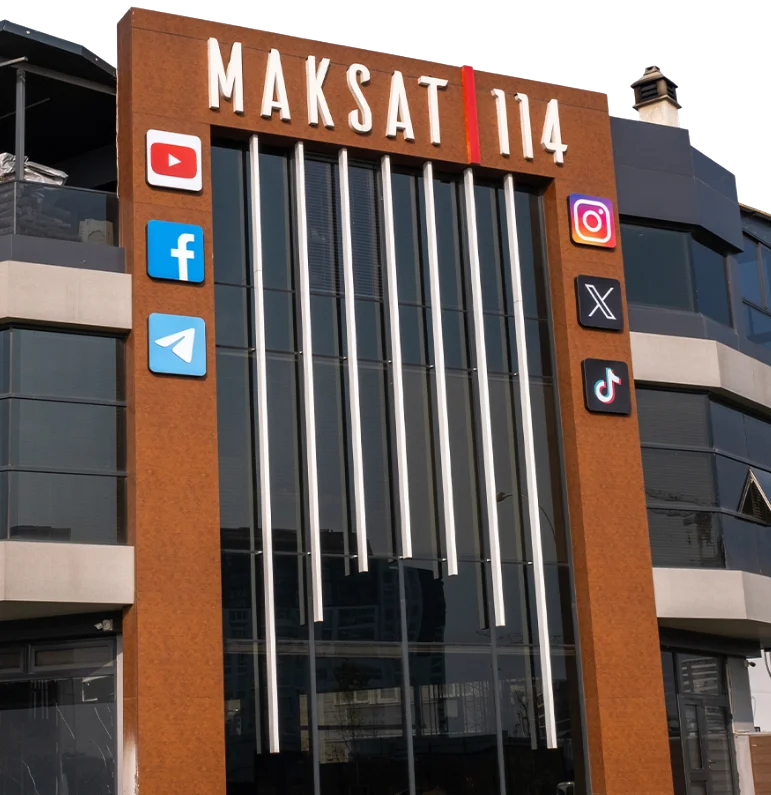 Maksat 114 binasının cephesi: bakır kaplama, dikey ışık çubukları, MAKSAT 114 yazısı ve sosyal medya tabelaları